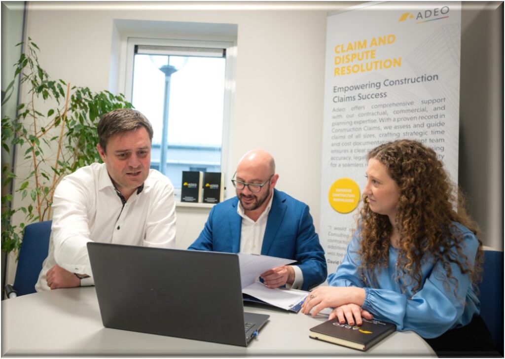 a group of people sitting at a table looking at a laptop